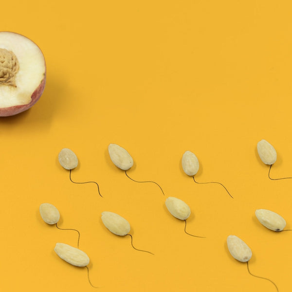 Halve perzik en amandelen met staartjes als zaadcellen, beeld voor vruchtbaarheid