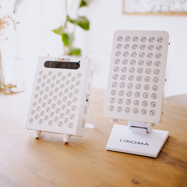 Twee witte LED-infraroodlampen van Liroma naast elkaar op een houten tafel, een op een standaard