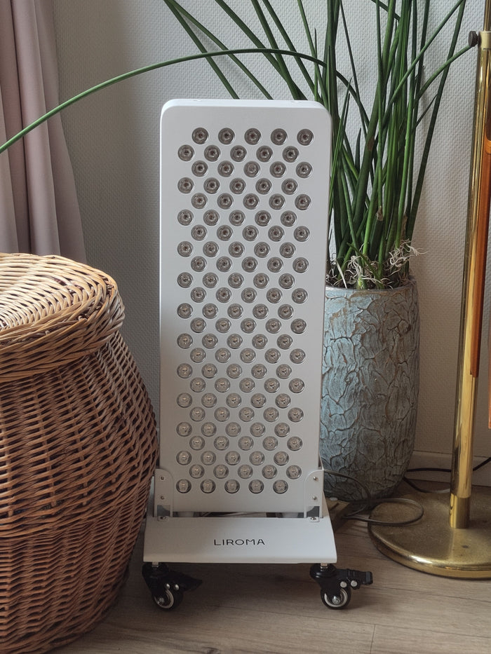 Liroma rood licht paneel op een verrijdbare standaard naast een plant in de woonkamer
