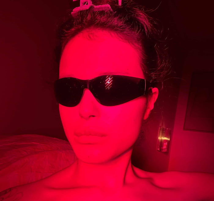 Vrouw met beschermbril tijdens een behandeling met rood licht therapie