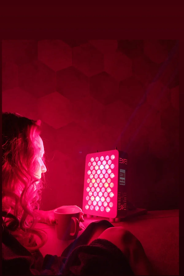 Vrouw met een mok zit in een donkere kamer voor een klein Liroma paneel op tafel