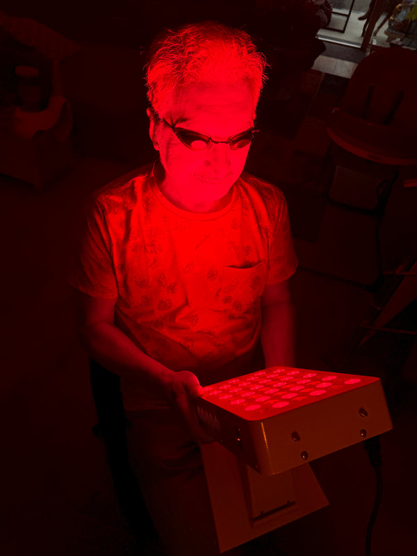 Vrouw met beschermbril houdt een klein Liroma paneel vast waarvan de leds rood branden