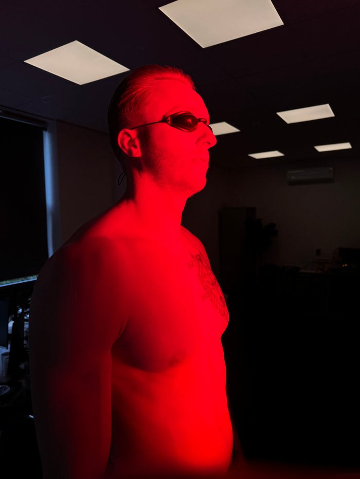 Man met beschermbril tijdens een behandeling met rood licht therapie