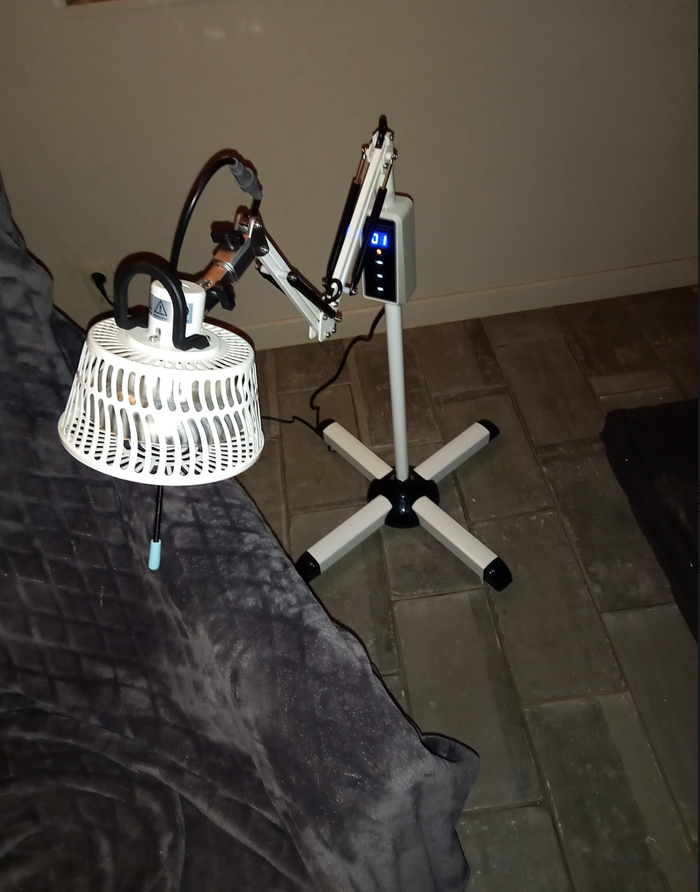 TDP-lamp op een verrijdbare standaard boven een bed