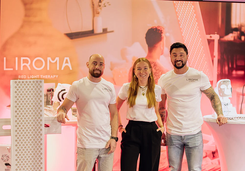 Il team di Liroma allo stand con un pannello a luce rossa