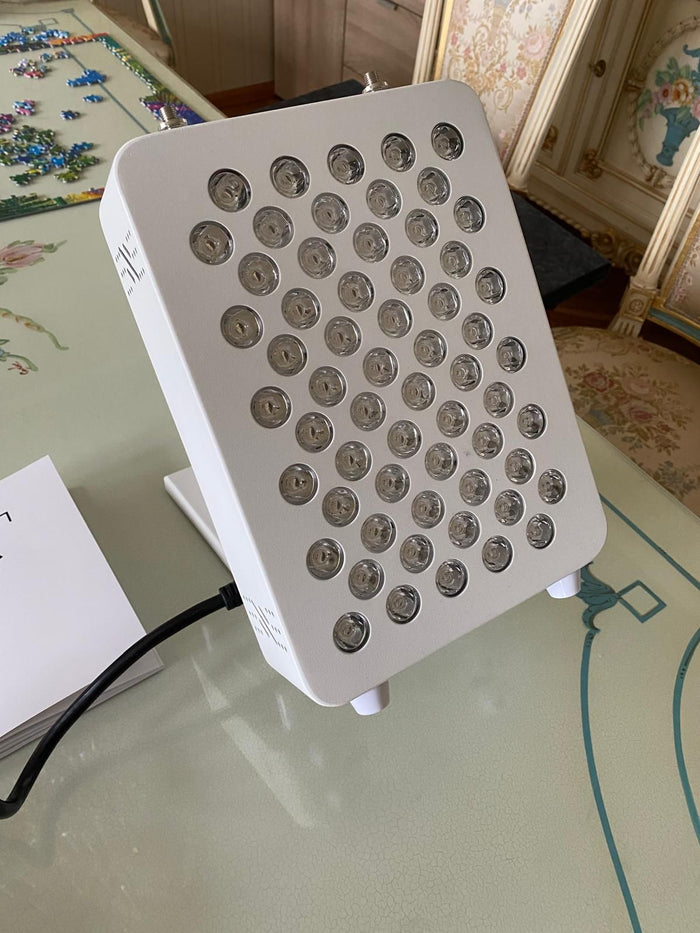 Compacte rood licht therapie lamp met leds op een tafel