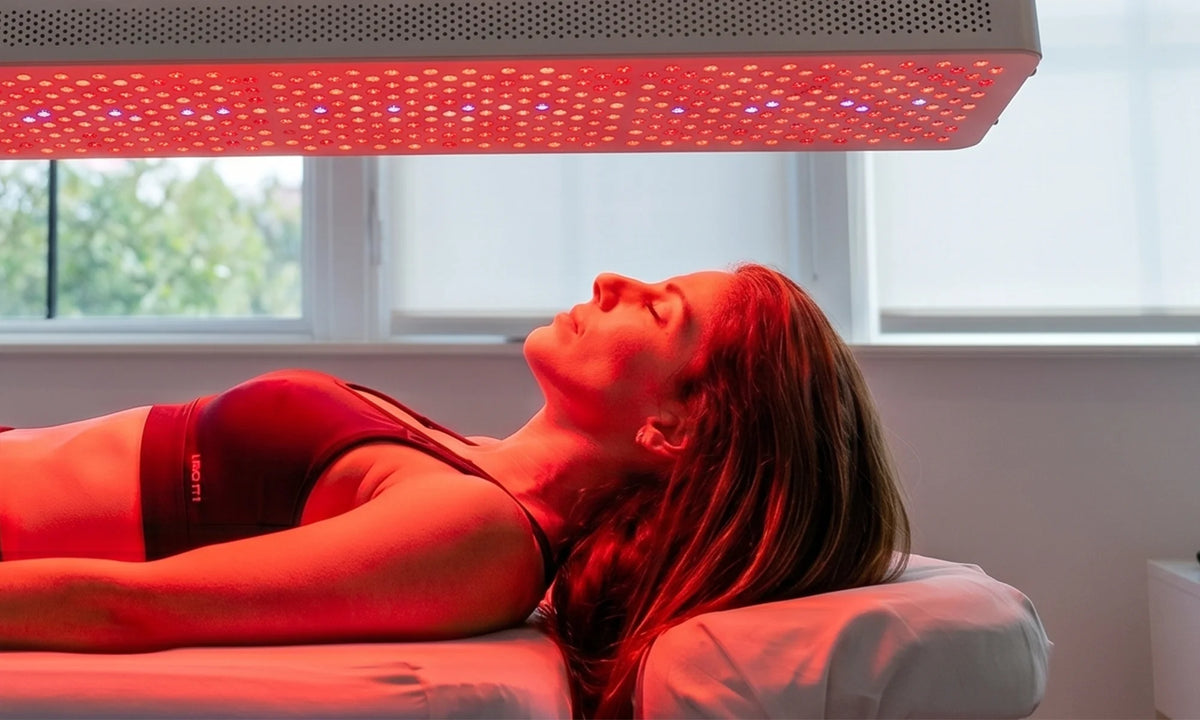 Vrouw ligt onder een horizontaal opgehangen rood licht therapie paneel