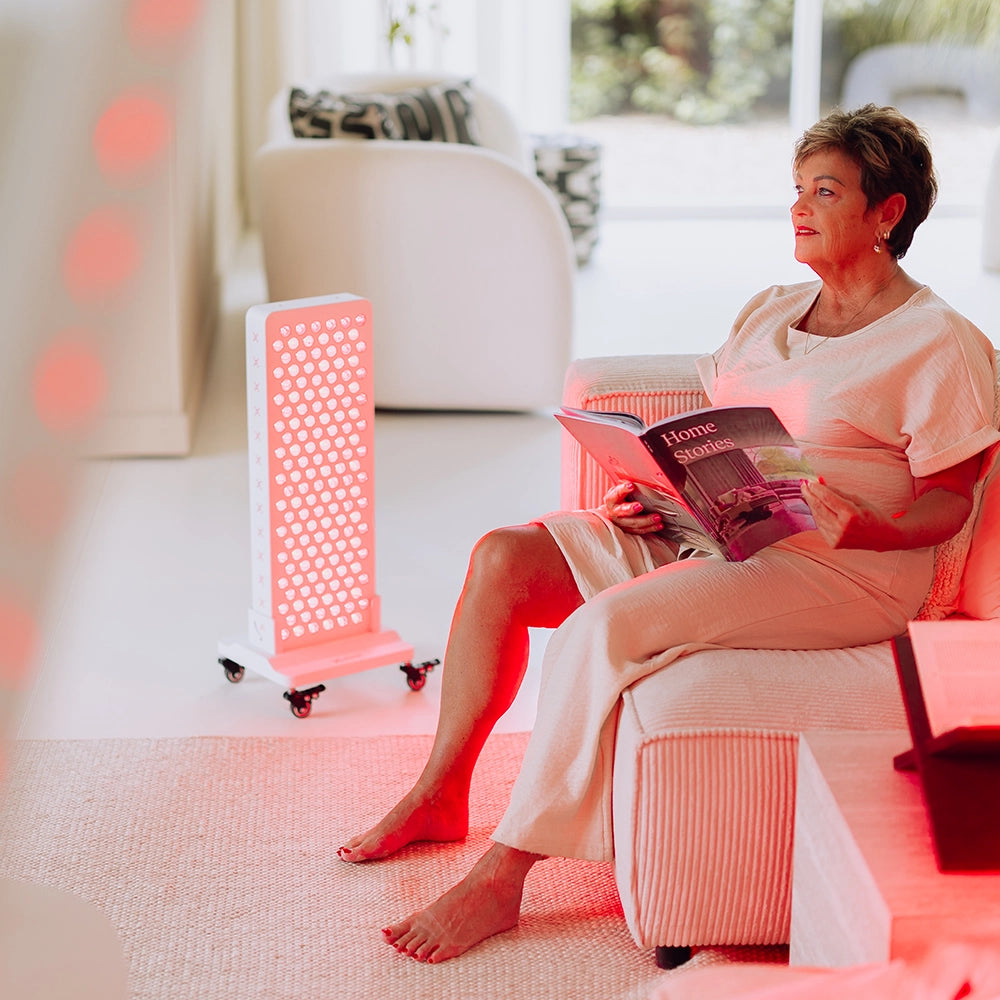 Vrouw leest naast de Liroma Advanced rood licht therapie lamp in de woonkamer