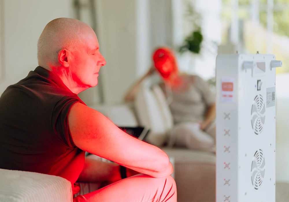 Man en vrouw gebruiken samen rood licht therapie in de woonkamer